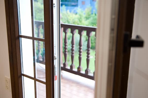 Puerta de balcon de PVC con acabado imitación madera instalada en una reforma de vivienda integral en Donosti por Reformas Urgull