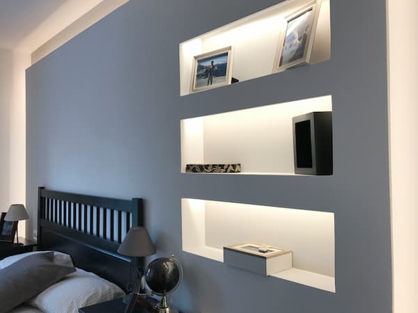 Doble pared tabicado cabecera de dormitorio con estanterías realizada en pladur